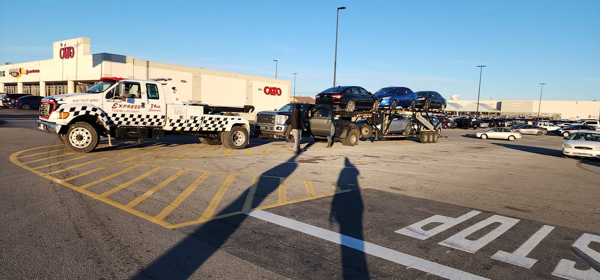 Express Towing and Recovery truck alongside a vehicle transporter