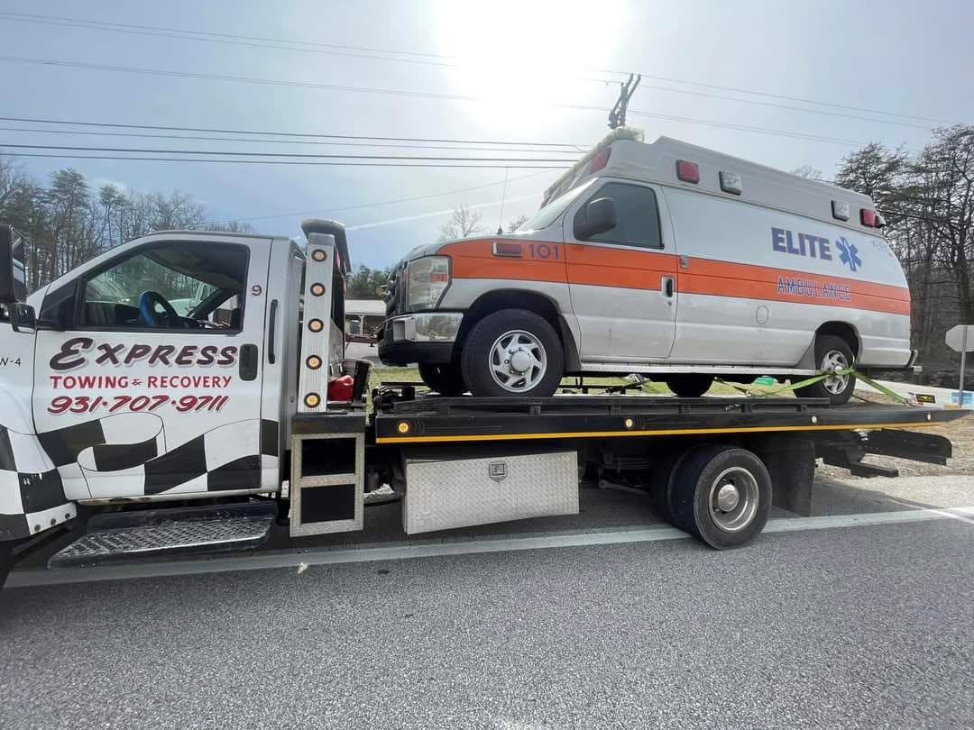 Express Towing and Recovery flatbed carrying an ambulance